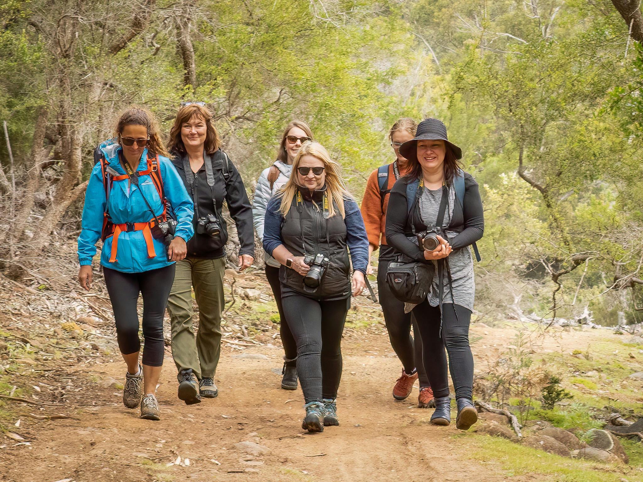 A group of female photographers walking along a nature trail