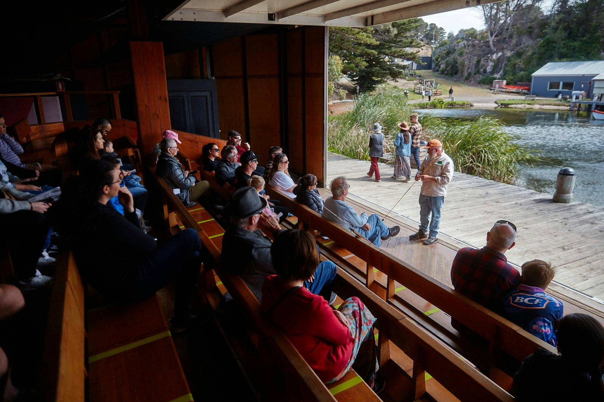 people seated on benches while a man addresses them