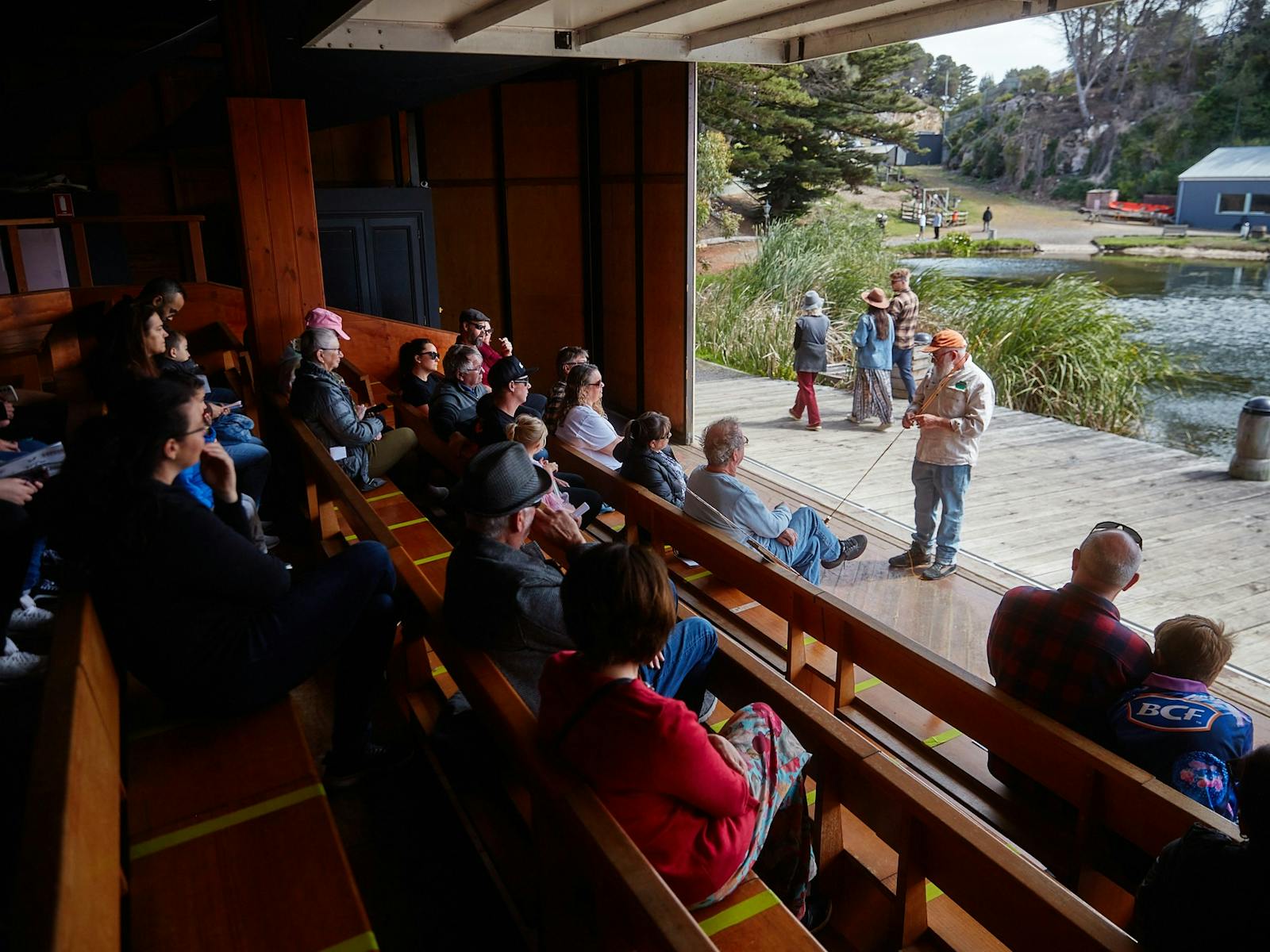 people seated on benches while a man addresses them