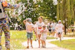 Kids running through bubbles in a park