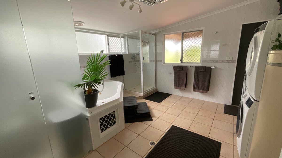 Main bathroom/laundry with separate bath, standalone shower, washing machine and dryer