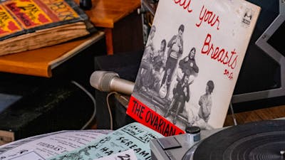 A mock studio desk with record reading 'Beat Your Breasts' in the 2XX exhibition at CMAG