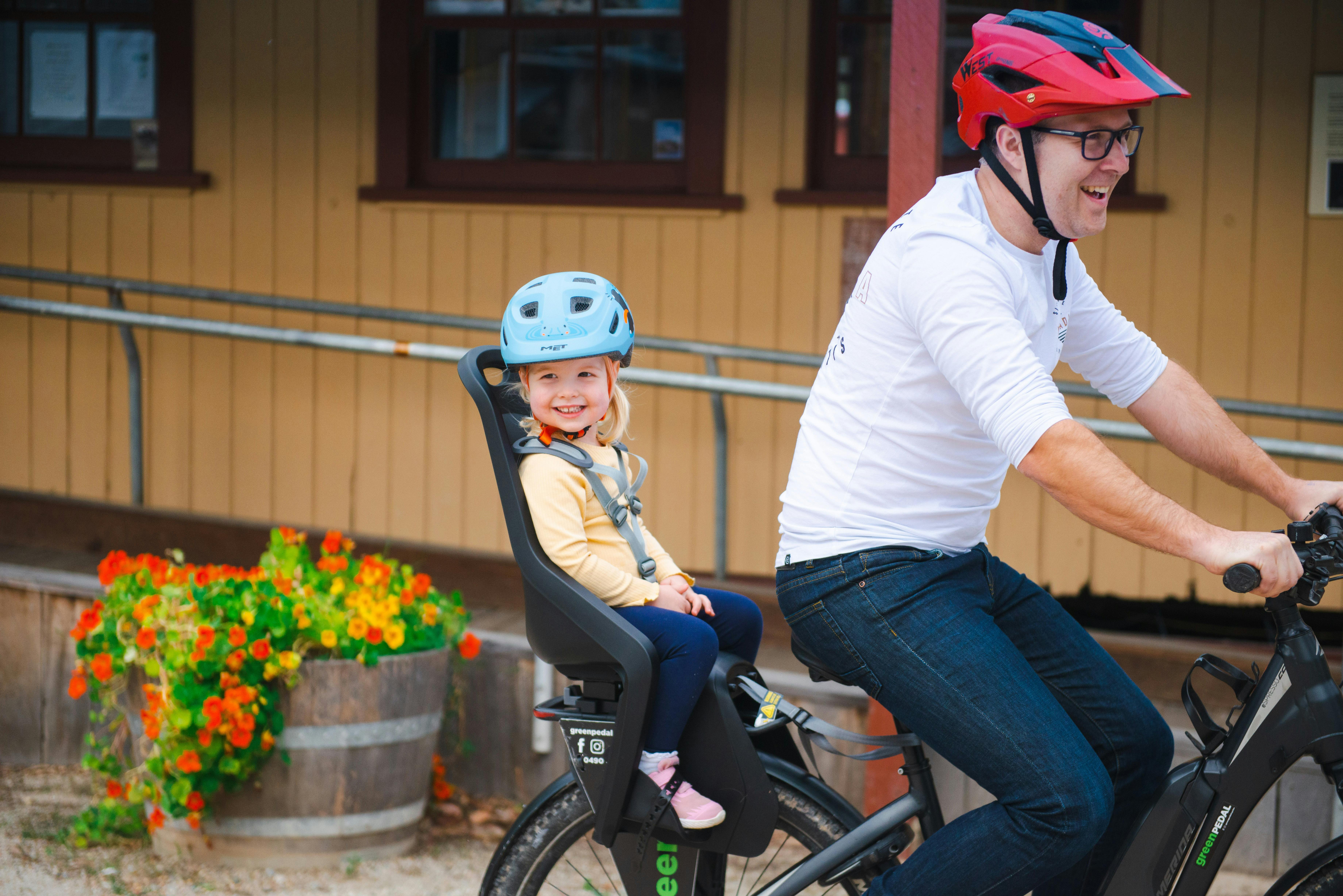 Man riding E-bike with child in baby carrier