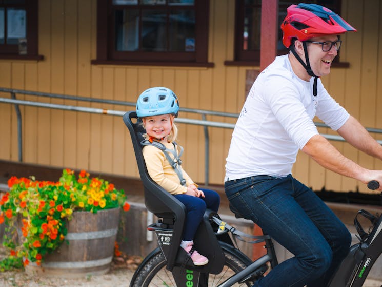Man riding E-bike with child in baby carrier