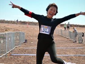 Competitor jumping into the air after crossing the finish line