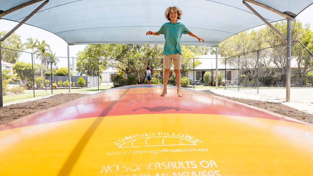 Child jumping on a giant jumping pillow laughing