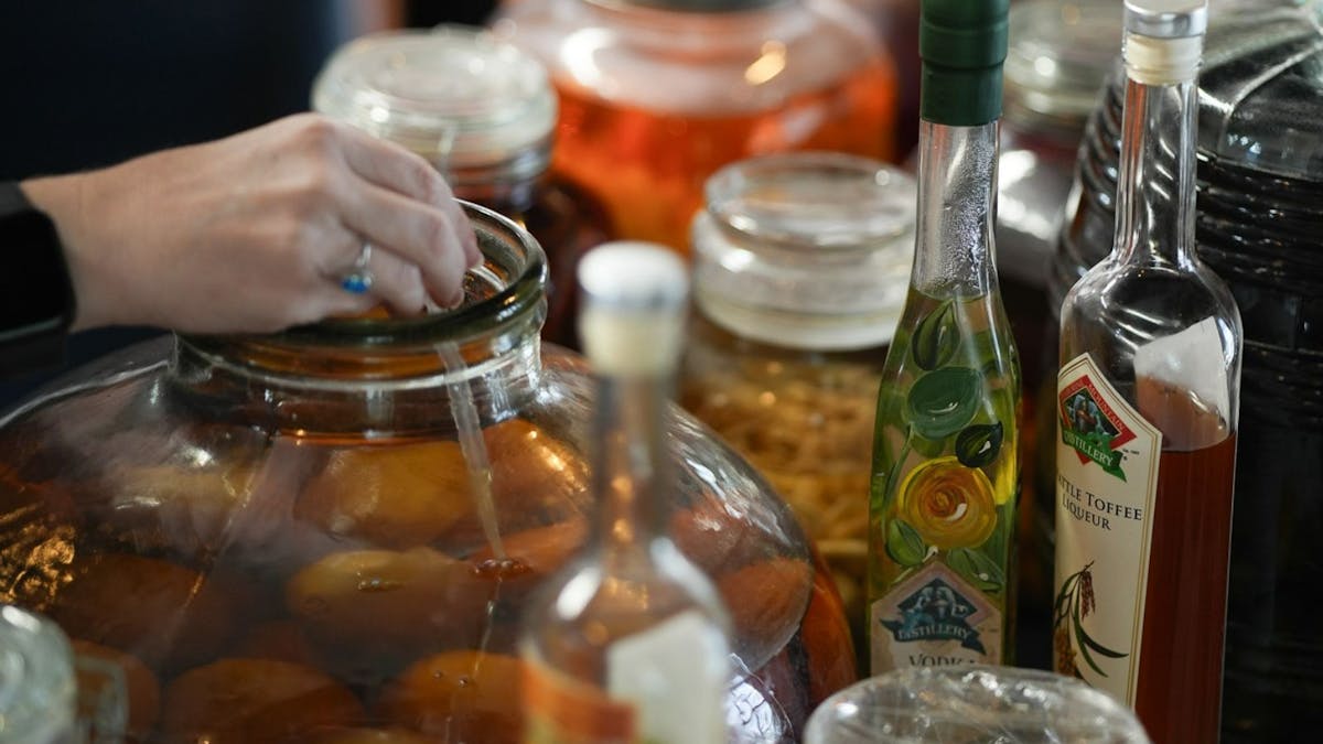 People choosParticipant selecting and adding tinctures during spirit blending class.ing tincture People choosParticipant selecting and adding tinctures during spirit blending class.ing tincture