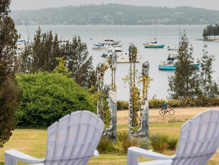 Two white deck chairs with Lake Macquarie and Jamie North's sculpture in the background