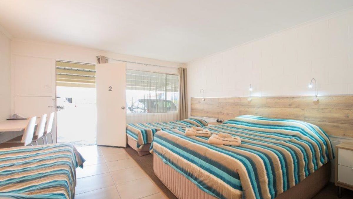 Tripple queen room with blue and pink bed cover, terracotta tiles Tripple queen room with blue and pink bed cover, terracotta tiles