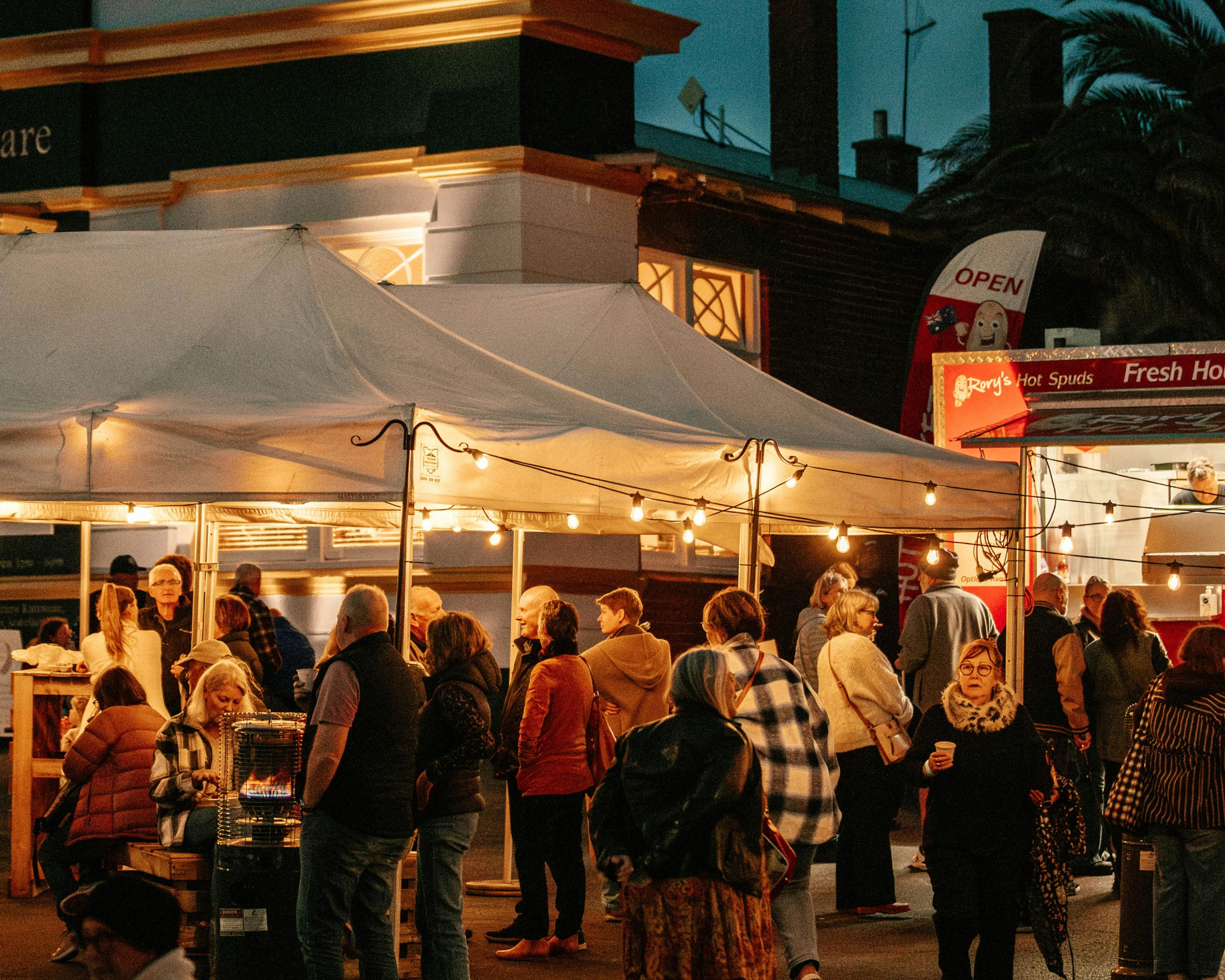Early evening, people in food stall street, festoon lighting