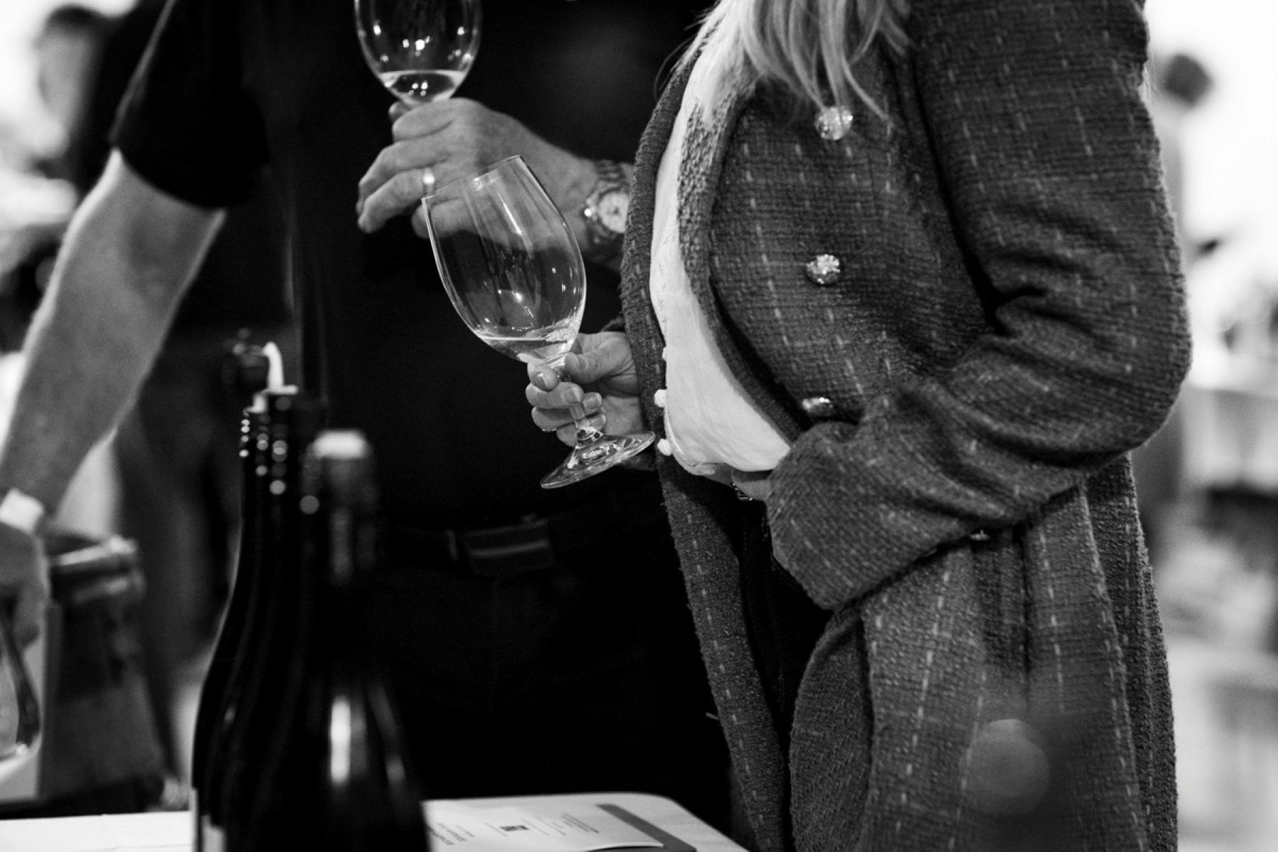 black and white image of a man and woman holding wine glasses