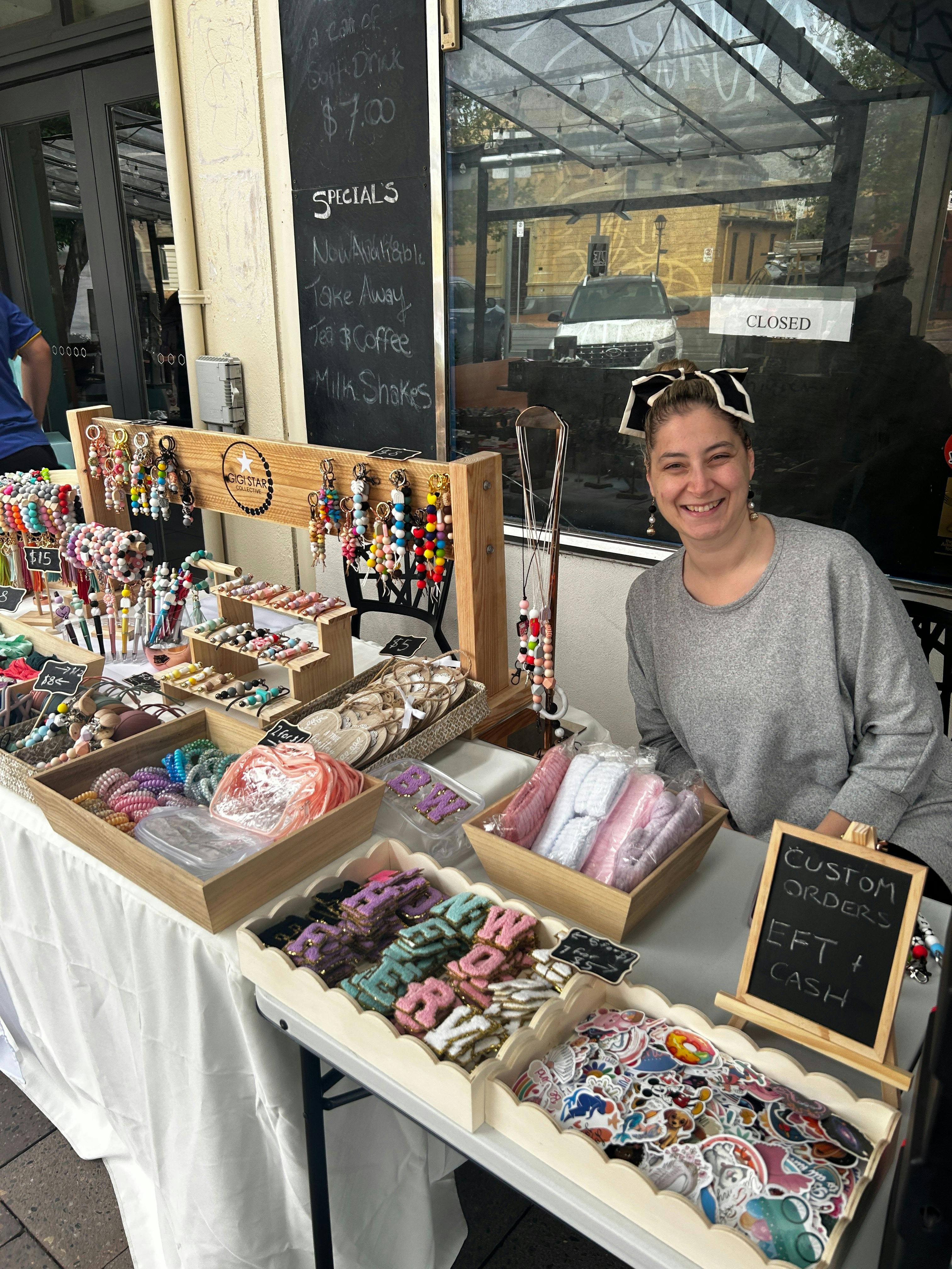 Local maker showcasing colourful handmade jewellery and accessories at Meandering Markets.