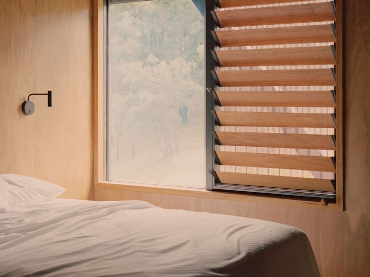 Image of room at The Bridge with bed, wood paneling and view from window