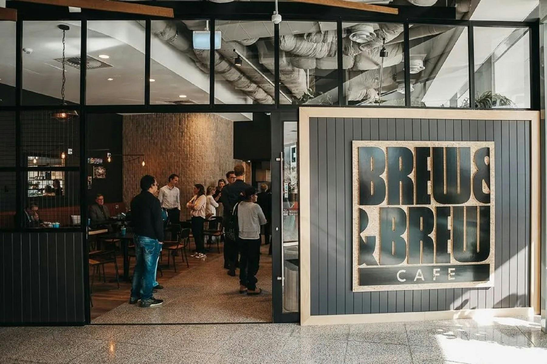 Front of cafe with doors open and people waiting to order