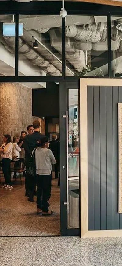 Front of cafe with doors open and people waiting to order