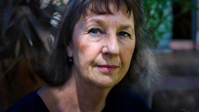 A close up image of a woman with long dark hair and a fringe