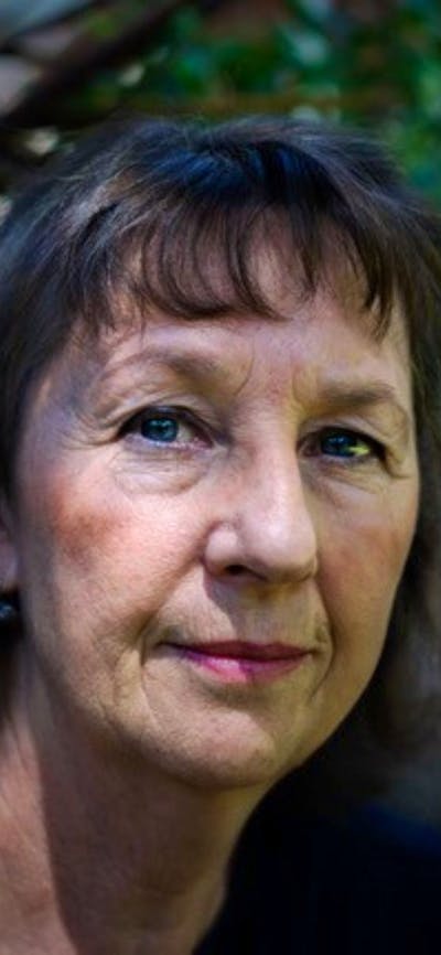 A close up image of a woman with long dark hair and a fringe