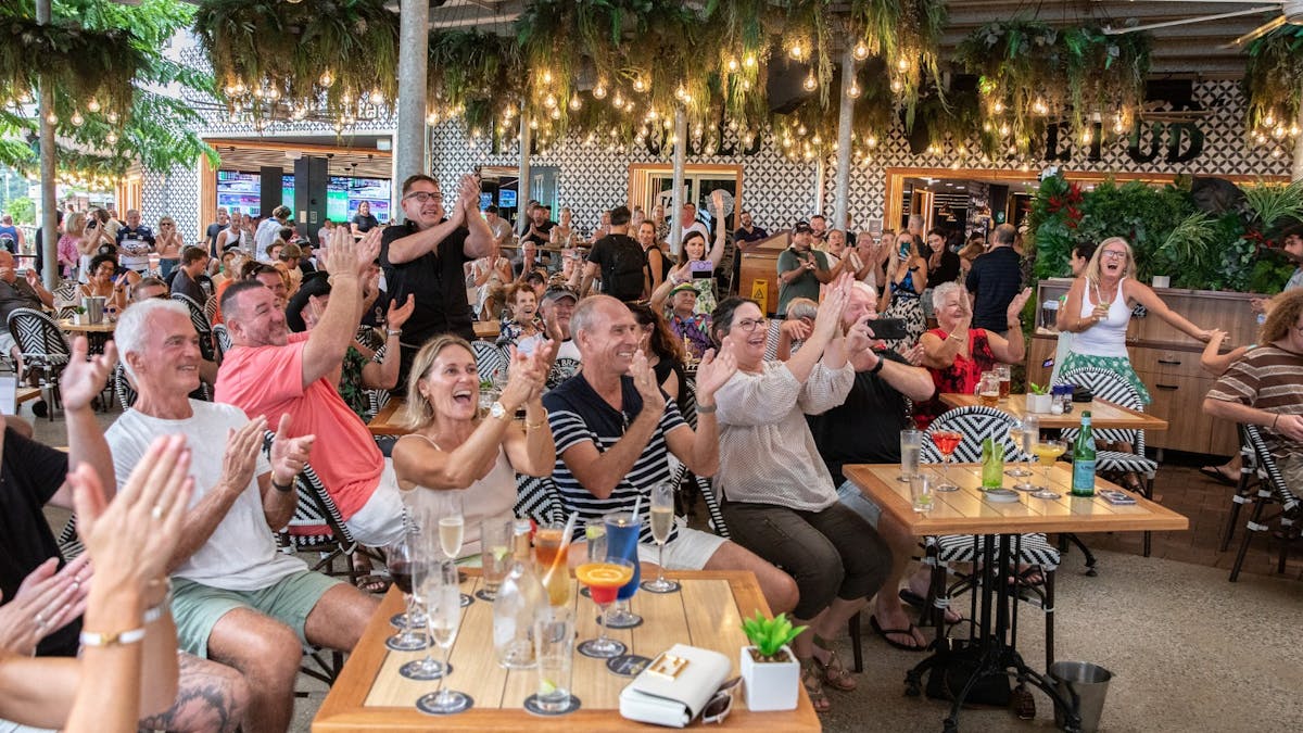 Audience at The Pub Airlie Beach Hotel cheering, enjoying live music in a vibrant outdoor setting