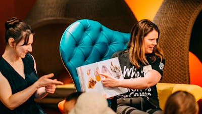 Photo of a Museum staff member and an Auslan interpreter signing a book in the Discovery Centre