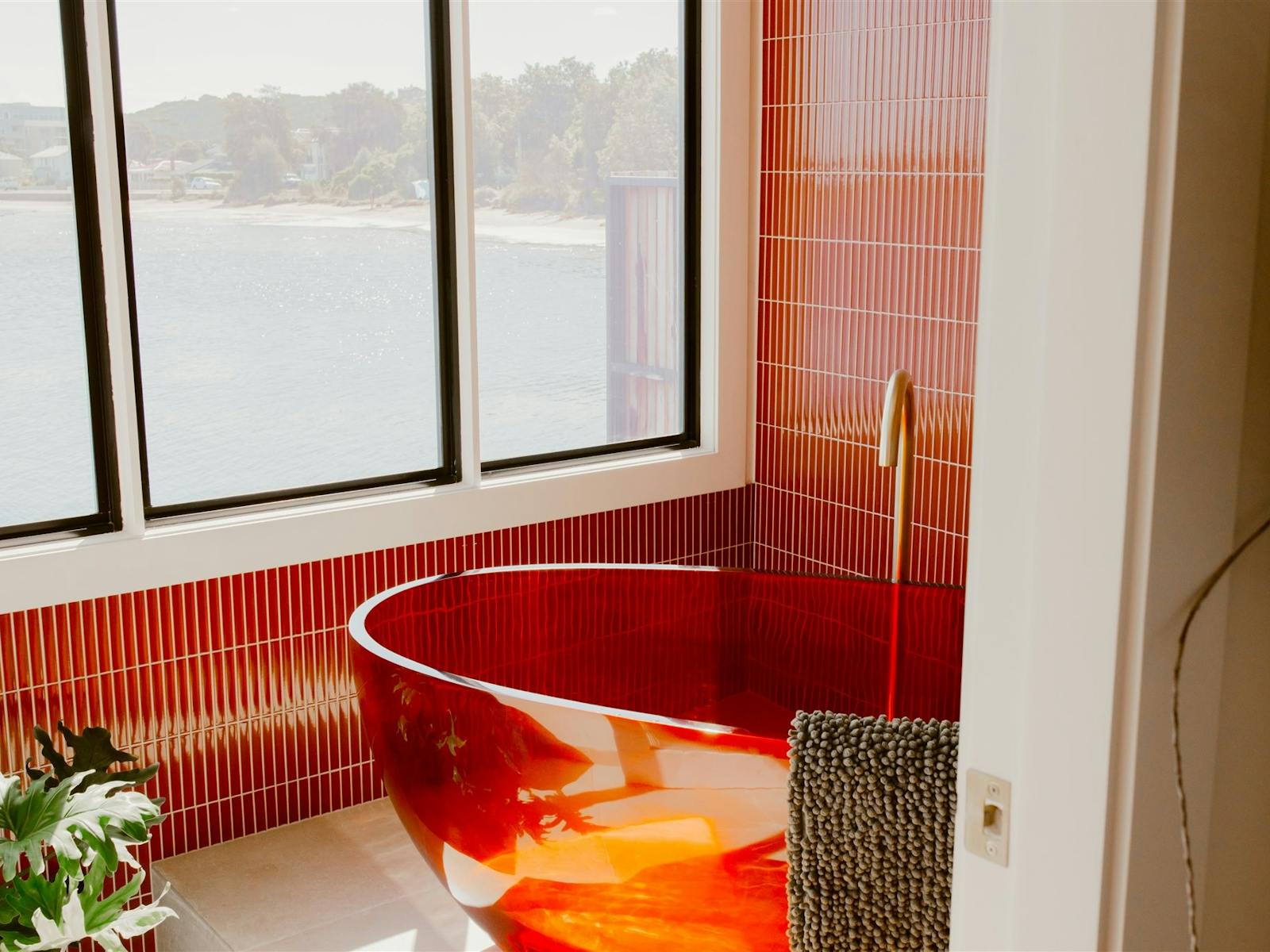 Red Bathtub and window overlooking the lake