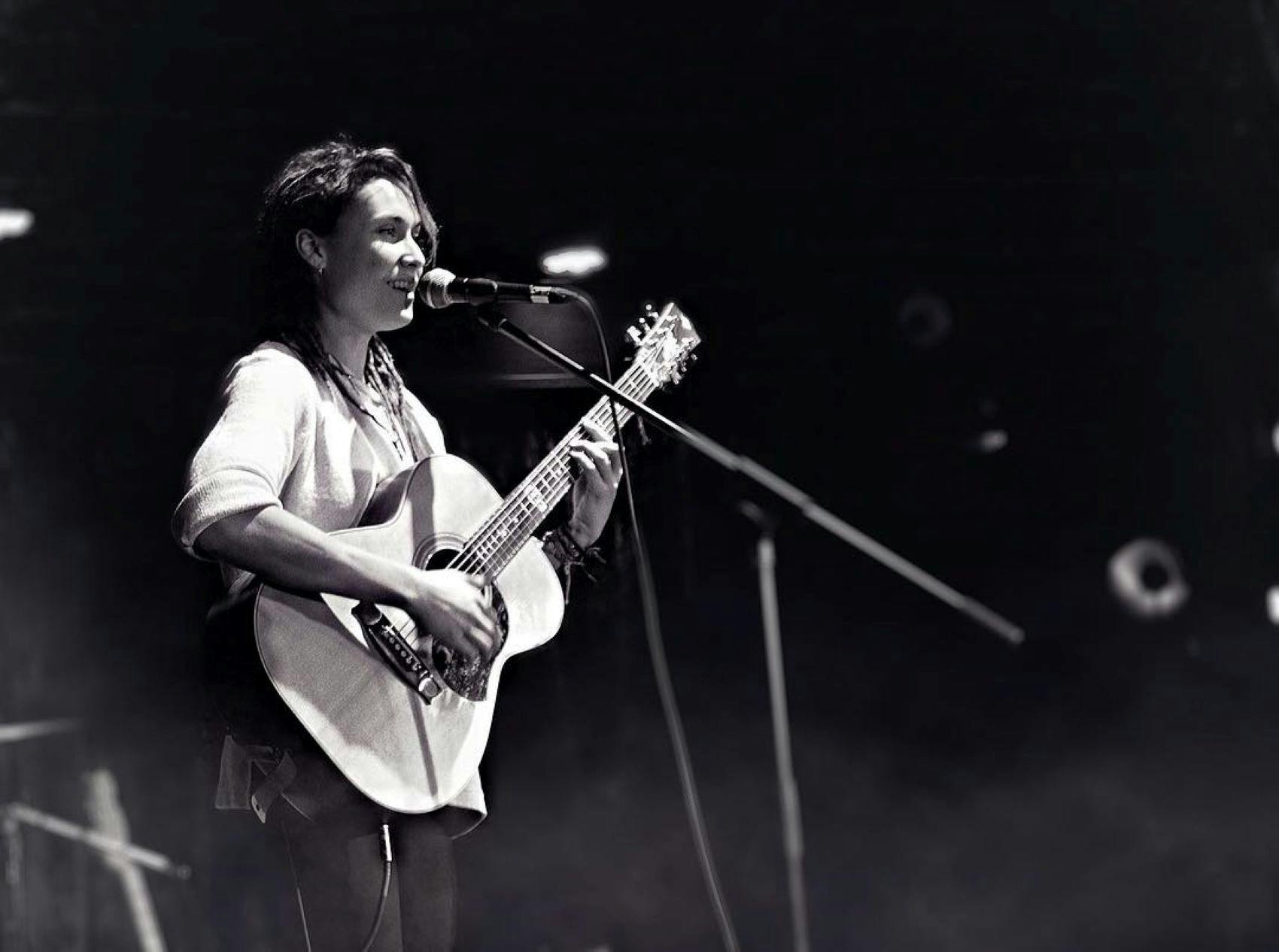 Singer with acoustic guitar and microphone