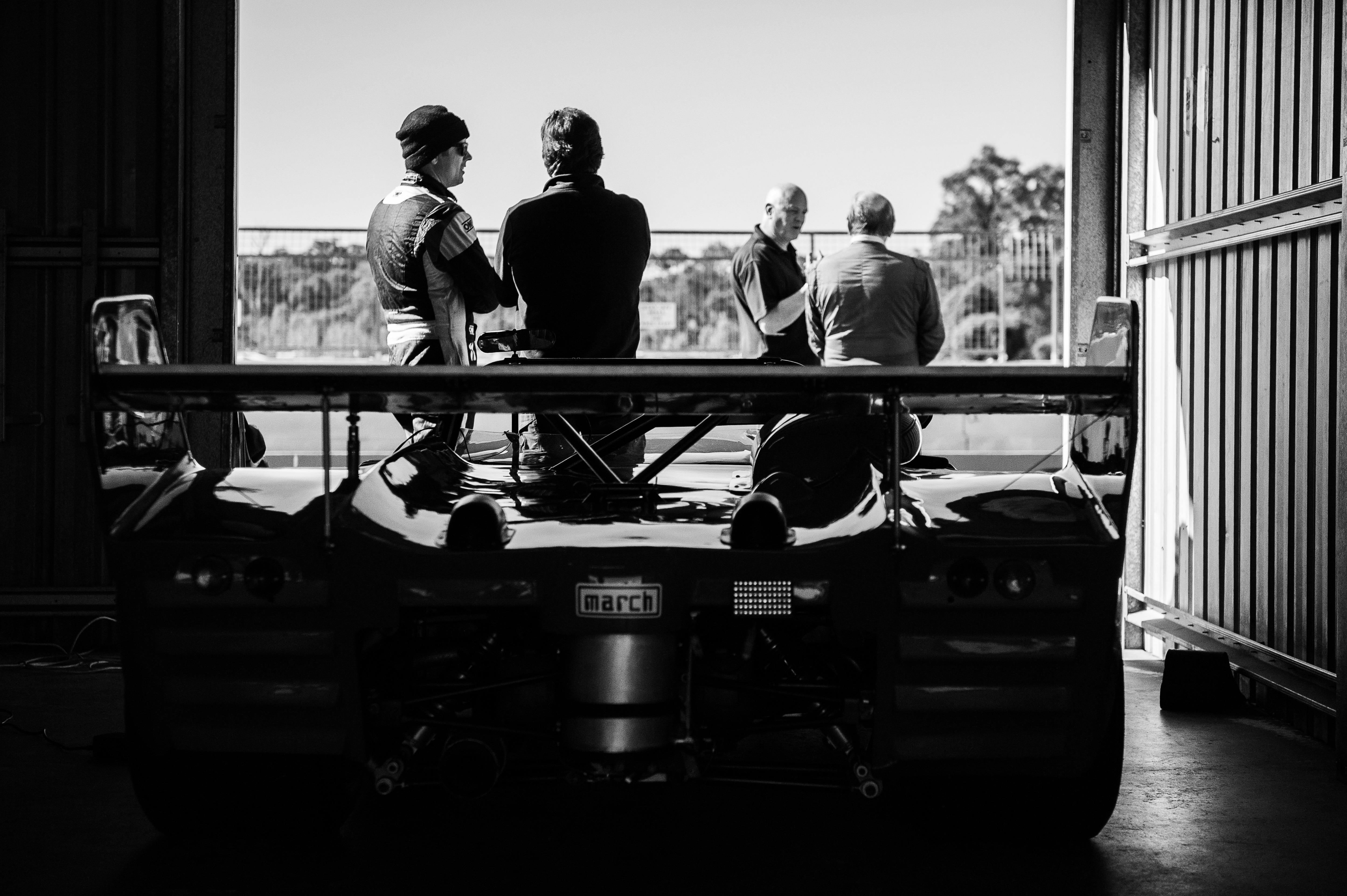Sports car in garage with people