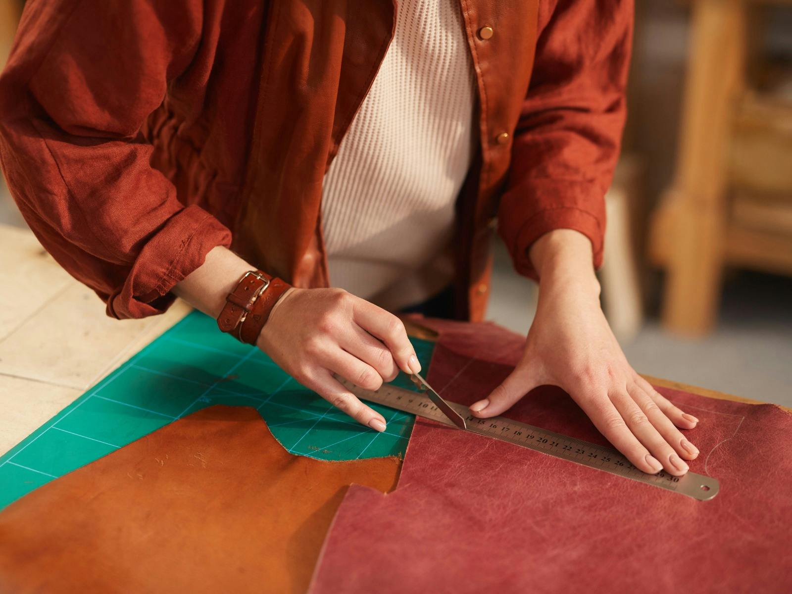 Pair of hands cutting leather