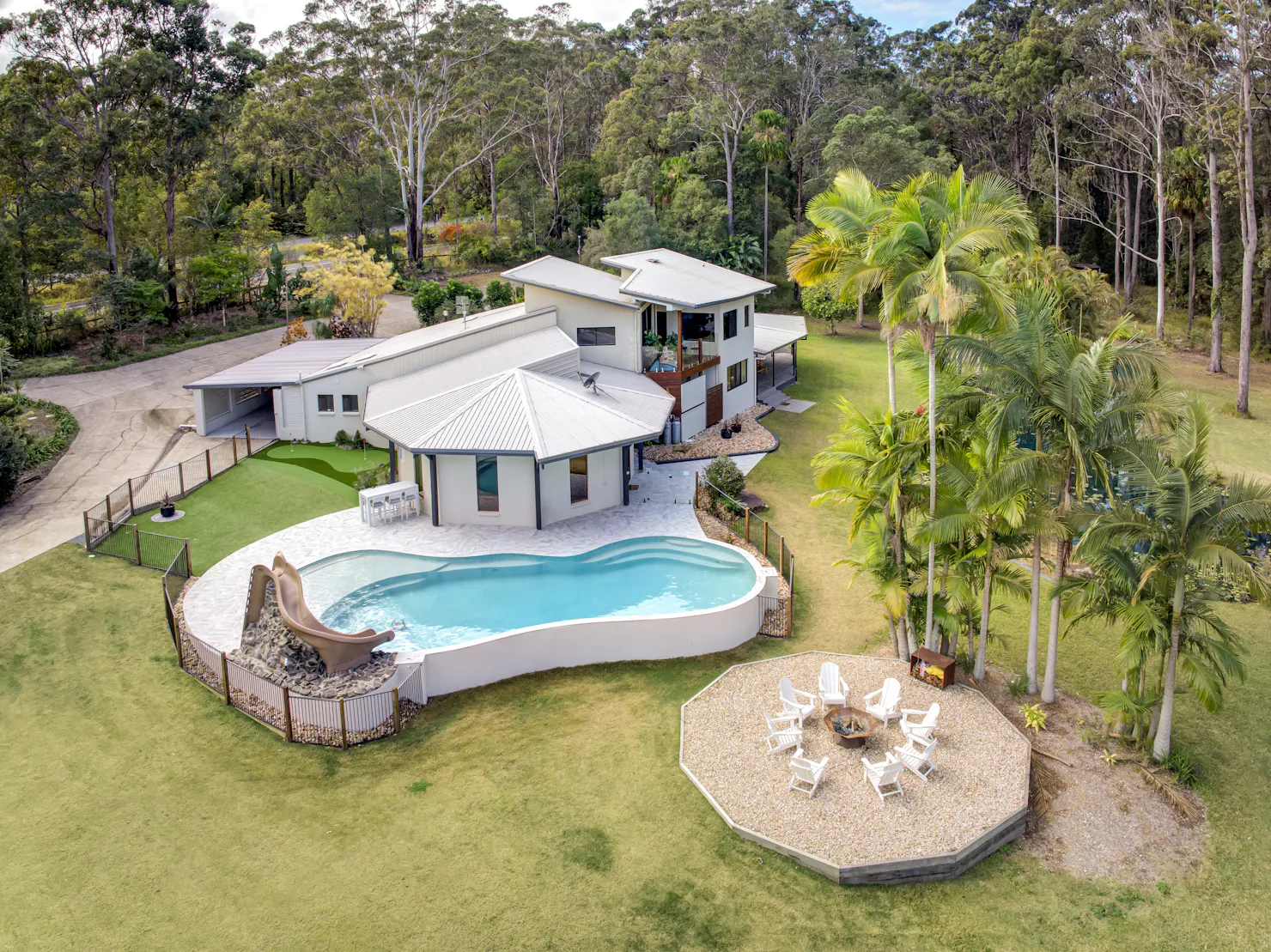 Pool overlooking the stunning rainforest with a slide and fire pit.