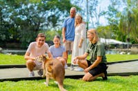 Group of 4 visitors getting up-close with a wallaby with a wildlife keeper guide at Wildlife Habitat