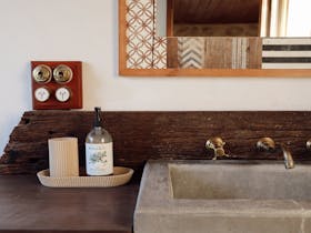 Bathroom vanity with stone basin and timber details at 1856 Cottage accommodation in Robe South Aust