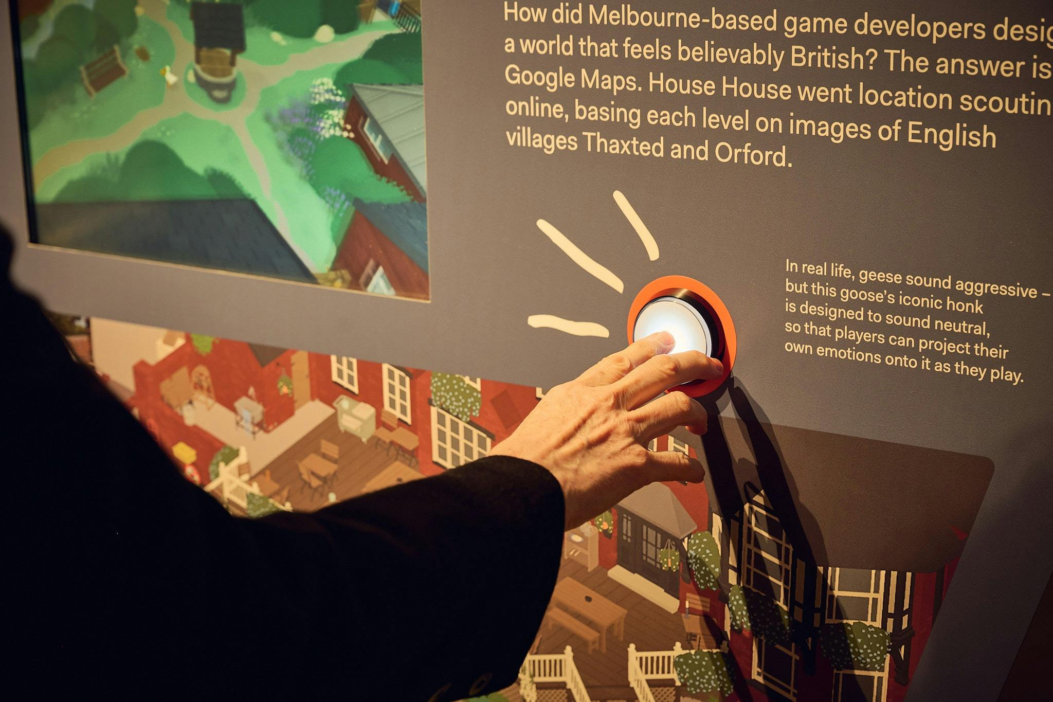 A person presses a light up button as part of a colourful exhibition display