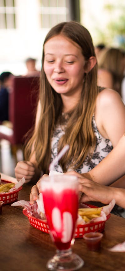 Three teenagers sitting down to their burgers