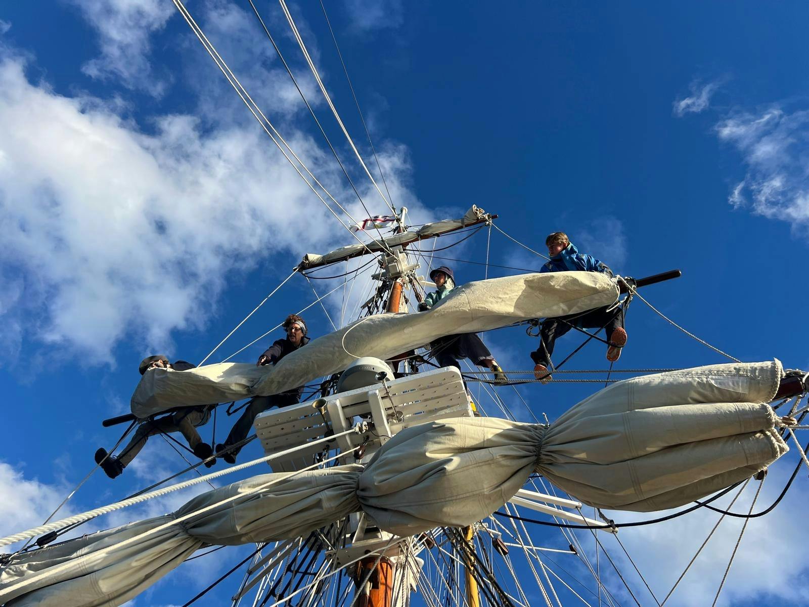 Youth crew up the mast handling the sails