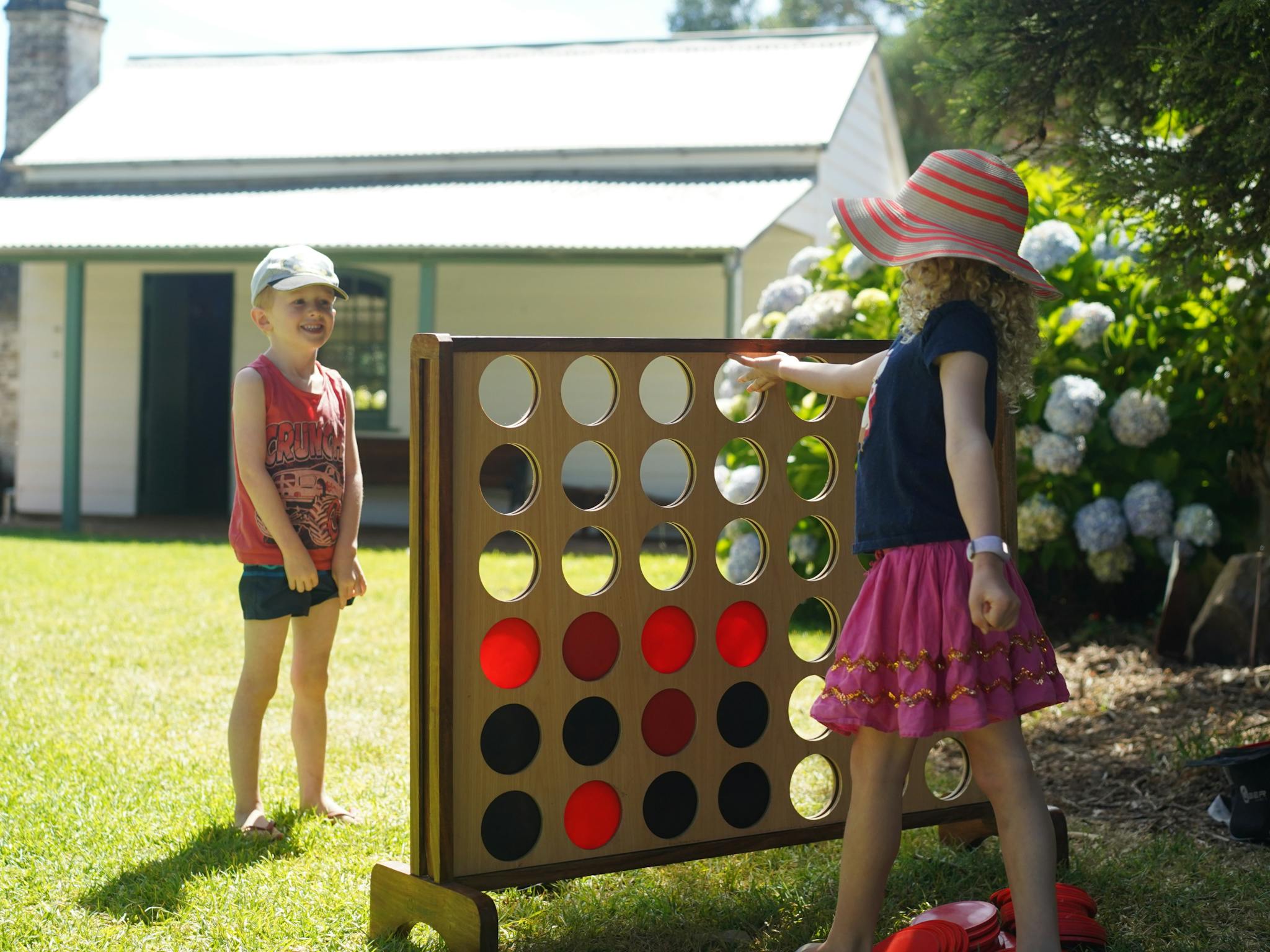 Two children playing giant connect four at Churchill Island