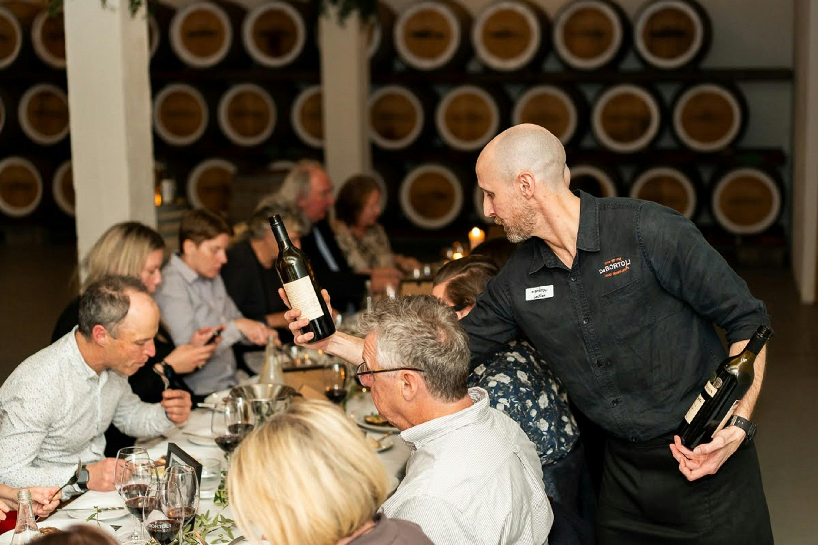 waiter pouring red wine for guests at the Legacy Dinner - De Bortoli Rutherglen Estate