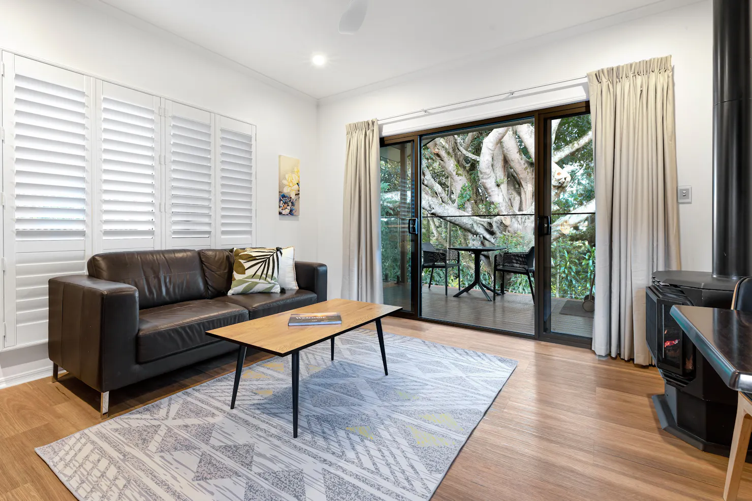 Image of the lounge of Figtree Villa looking out through the verandah to the fig tree