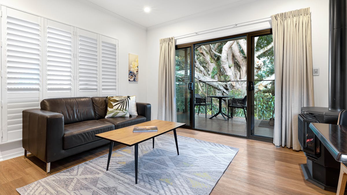 Image of the lounge of Figtree Villa looking out through the verandah to the fig tree