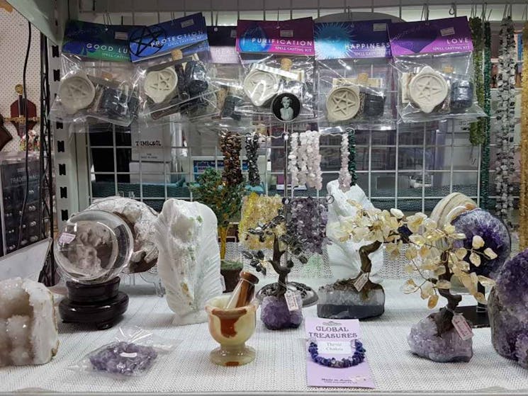 Table full of crystals of many types and spell casting kits.