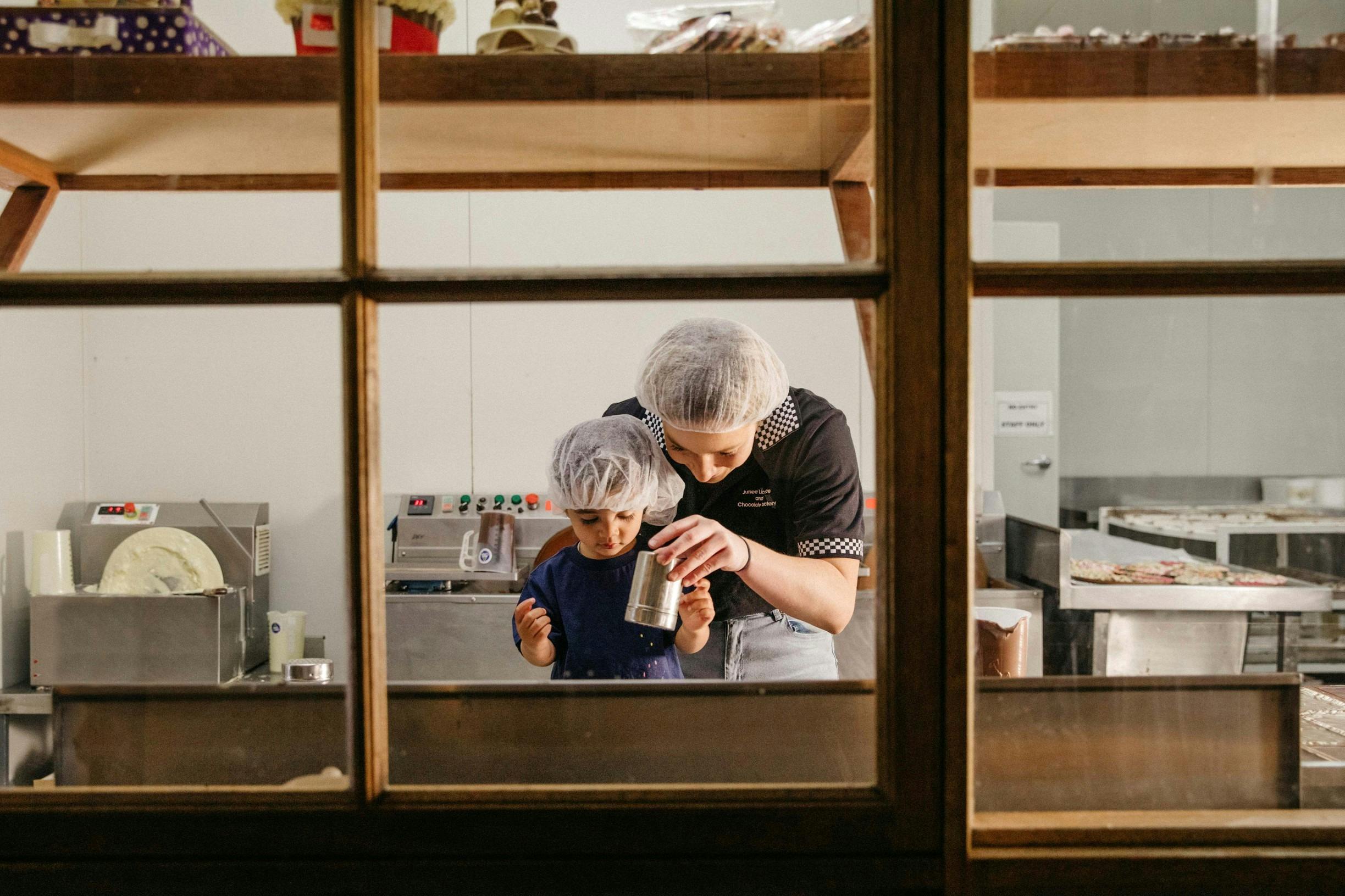 Junee Licorice and Chocolate Factory에서 거대한 초콜릿 주근깨 만들기 수업을 즐기는 어린 소녀