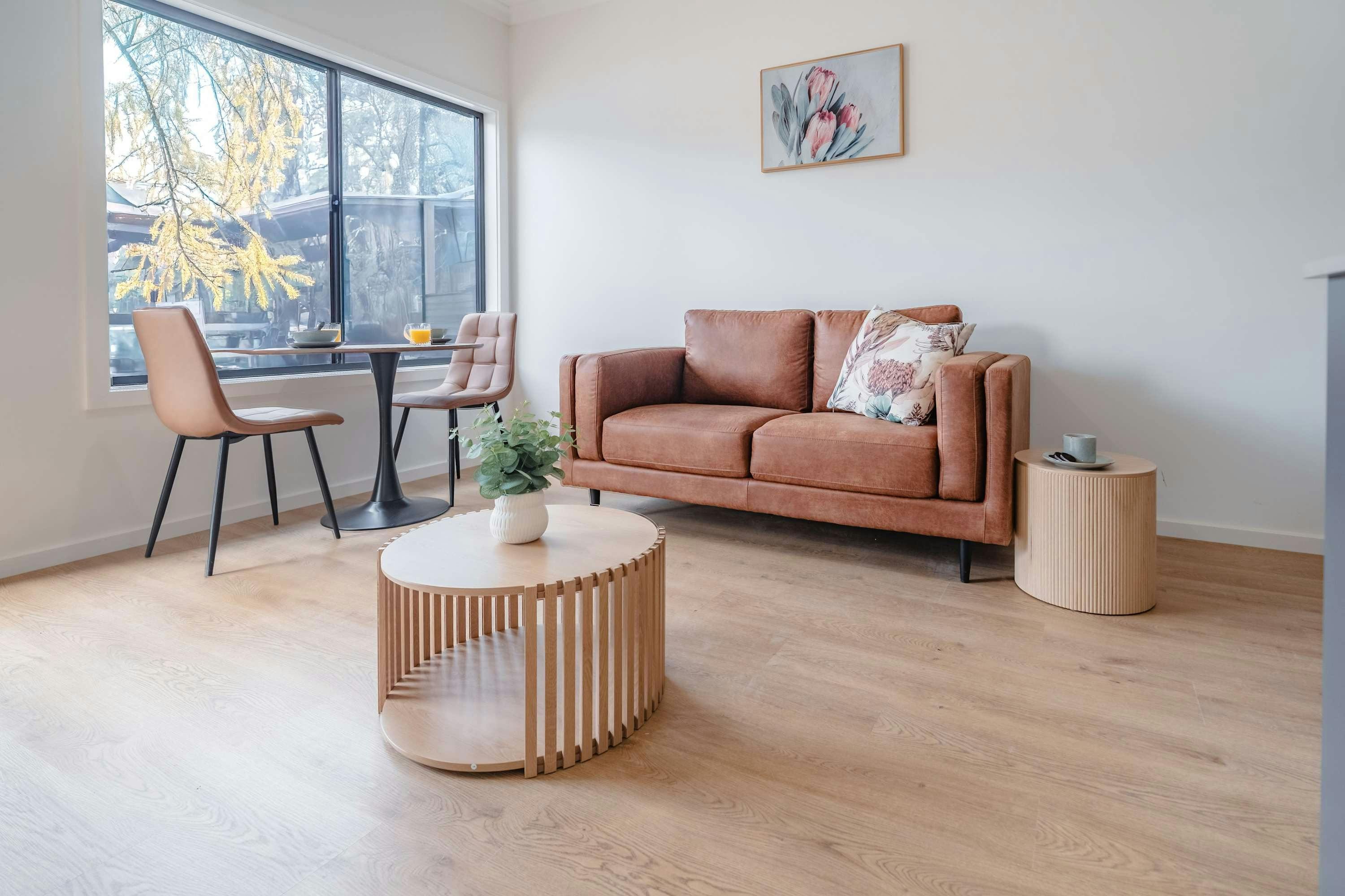 Living area with leather sofa, dining room