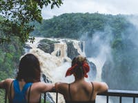 Two women looking at Barron Falls in full flow from lookout