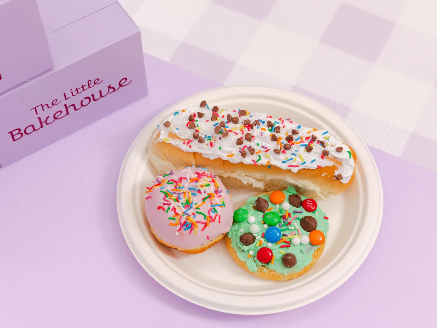 Donut, cookie and finger bun decorated sitting on a plate