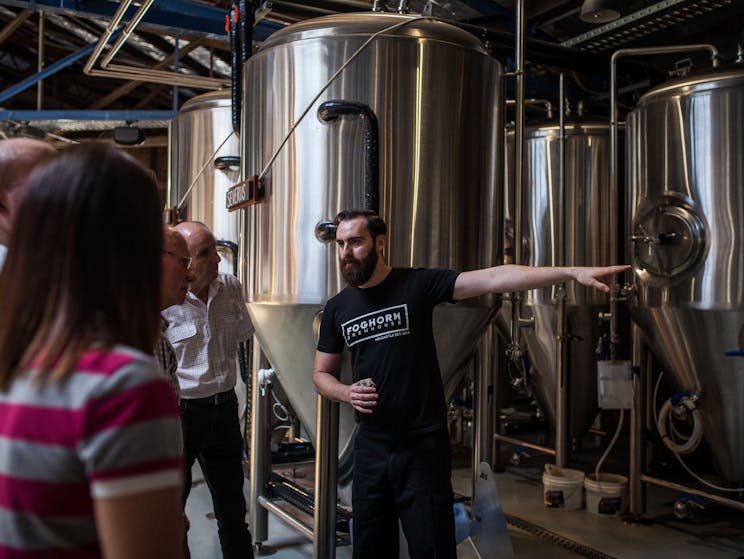 A member of the FogHorn Brewhouse staff conducts a tour in the middle of the brewery
