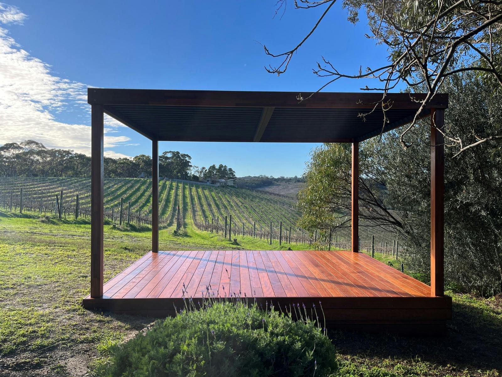 A hardwood deck with wooden pergola overlooking the vineyards