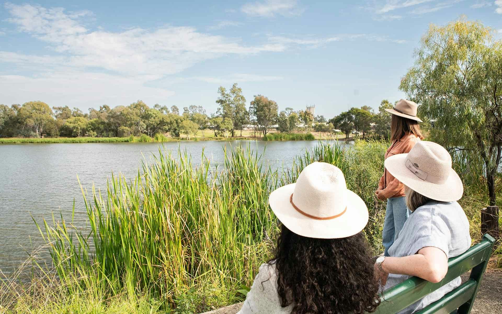 Two people sitting on a park bench overlooking the lake