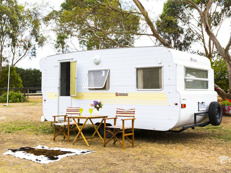 caravan with camp chair set up outside