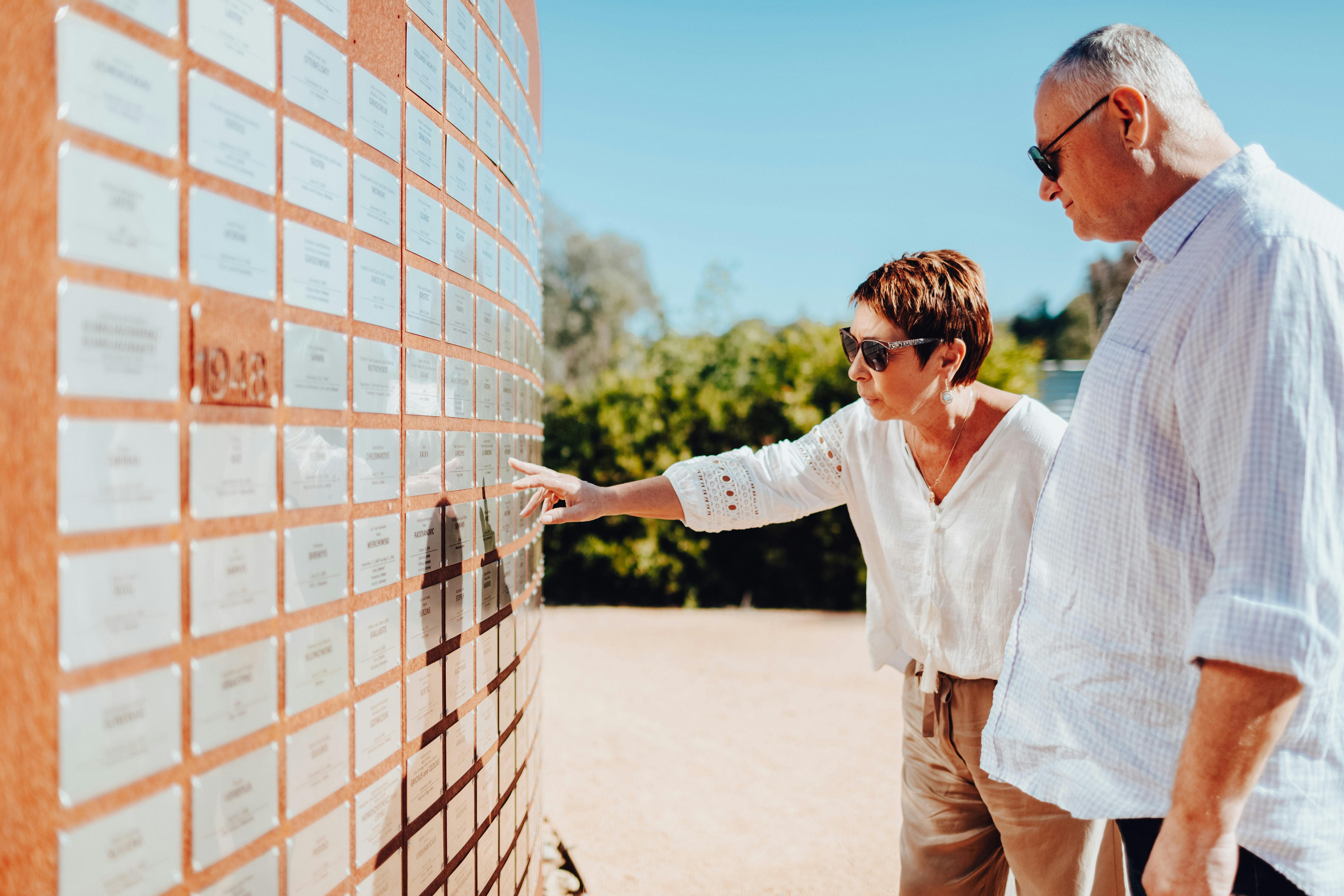 two people pointing at a placard at Bonegilla Migrant Experience