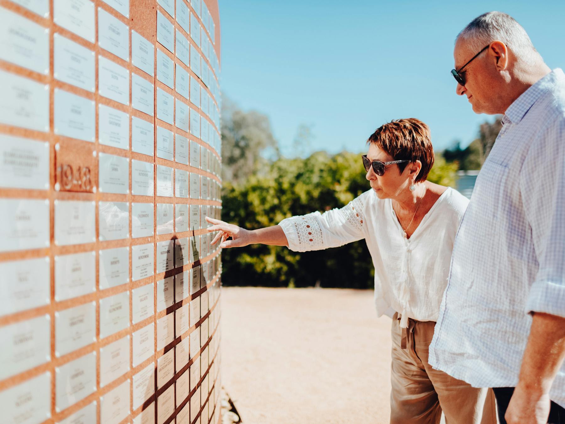 two people pointing at a placard at Bonegilla Migrant Experience
