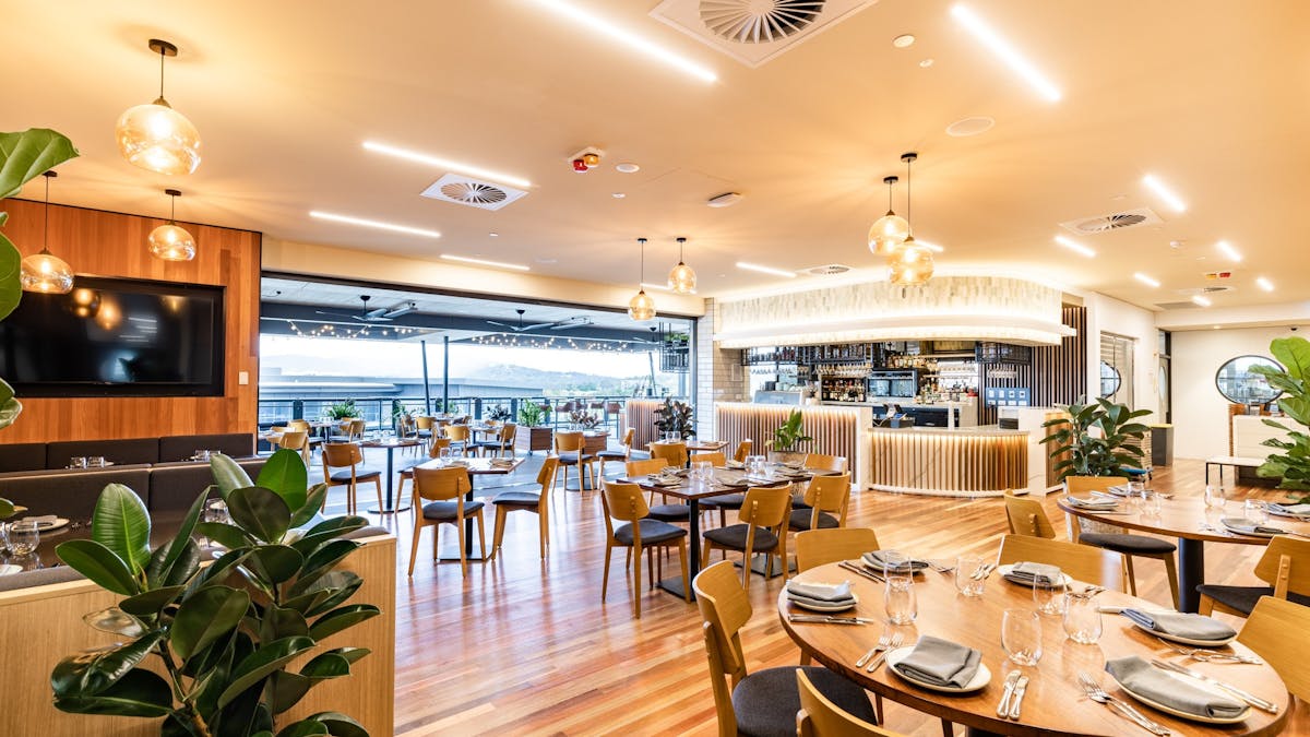 Warm wood tones, indoor and outdoor seating, beautiful lighting, welcoming space