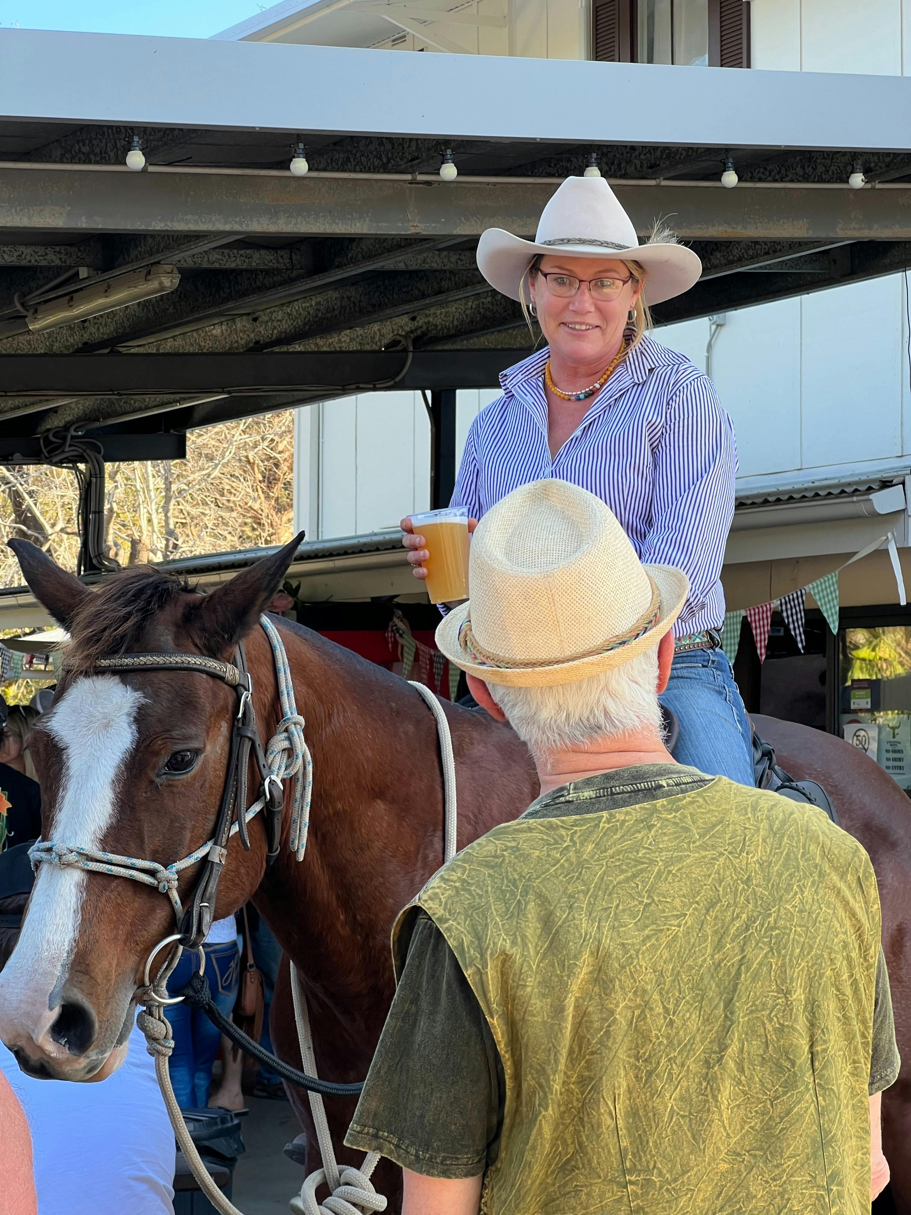A lady holding a beer is seated on a horse in the beer garden at The Tylagum Hotel